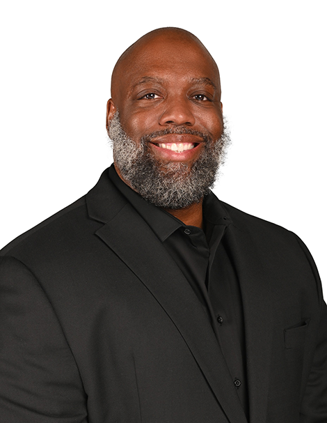 James Reed smiling in a suit on a white background