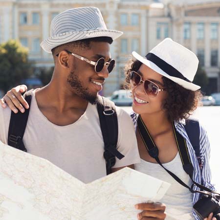 Happy couple with white hats and sunglasses as tourists.