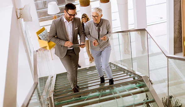 Group of businessmen and businesswomen walking and taking stairs in an office building